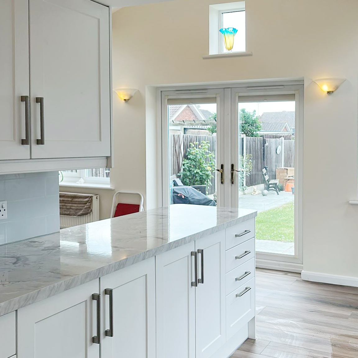 Bright open-plan kitchen with island and French doors to the garden